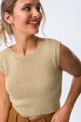 Musculosa color dorado de tejido de punto calado, con cuello redondo y sisas amplias.