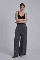 Pantalón palazzo gris con apliques de lentejuelas y mostacillas formando flores.
