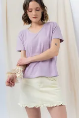 Minifalda de denim color crema con volados en los bolsillos delanteros y en el ruedo.