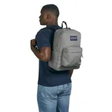 Mochila JanSport Superbreak gris con logo de la marca en el frente, un compartimento principal con cierre, un bolsillo frontal con cierre y dos bolsillos laterales abiertos.