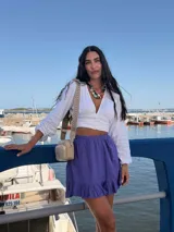 Bandolera pequeña de símil cuero color camel, con dos compartimentos principales con cierre. Incluye una correa ancha de tela estampada con motivos geométricos en tonos tierra y blanco.