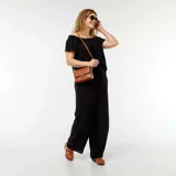 Blusa negra con escote bardot, mangas cortas y corte holgado.