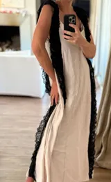 Vestido largo de estilo lencero color crema, con puntillas negras aplicadas verticalmente en el frente y la espalda.