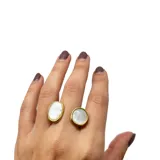Anillo abierto de acero dorado con dos piedras de nácar engarzadas.