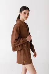 Bomber color coral confeccionada en mezcla de algodón y lino, con cierre frontal y puños elásticos. Presenta un bordado grande en la espalda inspirado en la colección La Verdulería.