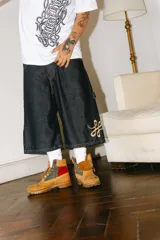 Bermuda carpintera de jean azul oscuro, corte baggy, con bordado dorado en el lateral, bolsillos grandes, bolsillo lateral y tira carpintera lateral.