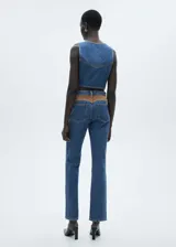 Pantalón de jean azul de corte recto, tiro medio, con cierre de cremallera y botón, cinco bolsillos y detalle en contraste.