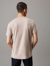 Remera color beige claro de corte recto, cuello redondo y mangas cortas. Estampado frontal con el logo de Calvin Klein Jeans en color blanco.