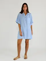 Vestido corto tipo camisola, color blanco, con cuello camisero, mangas cortas y bolsillo de parche con detalle de calado.