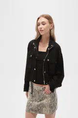 Campera color beige de manga larga, con cuello alto, cierre frontal con cremallera y botones a presión, bolsillos con solapa en el pecho y puños con trabilla ajustable.