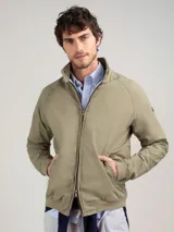 Cazadora tipo bomber color beige, con cierre frontal y bolsillos de solapa.