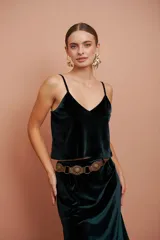 Top verde oscuro de terciopelo con breteles finos y escote en V. Presenta una flor bordada en la espalda.