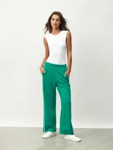 Pantalón blanco de corte ancho con una fina línea negra vertical en los laterales.