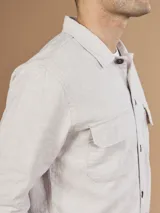 Camisa color verde militar de manga larga con cuello clásico, cierre frontal con botones y dos bolsillos de parche en el pecho.