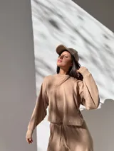 Conjunto deportivo color beige de tela waffle, compuesto por un buzo de corte cropped y un pantalón con cordón ajustable.
