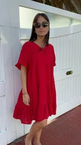 Vestido corto rojo con escote en V, mangas cortas con volados y corte escalonado.