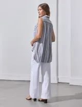 Camisa sin mangas de lino a rayas grises y blancas, con cuello clásico, cierre frontal con botones y dos bolsillos con solapa en el pecho.