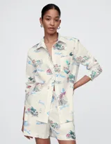 Camisa de lino color crudo con estampado de motivos playeros y nombres de destinos turísticos.