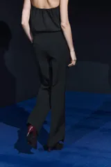 Pantalón negro de tiro medio, con trabillas en la cintura, bolsillos laterales y de vivo en la espalda, raya planchada en el delantero y pierna recta.