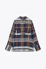 Camisa de mujer confeccionada en viscosa con estampado a cuadros en tonos azul, naranja, blanco y amarillo. Tiene cuello mao, manga larga con puños plisados, dos bolsillos de parche con solapa en el pecho, bajo recto y cierre frontal con botones ocultos.