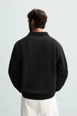 Sudadera color crema de corte recto, con cuello polo y cierre de cremallera metálica.