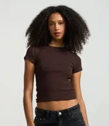 Remera negra de rib de algodón, con cuello redondo y mangas cortas. Corte ajustado y largo a la cadera.