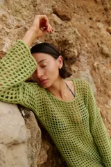 Vestido corto de crochet color verde militar, con mangas largas y calce suelto.