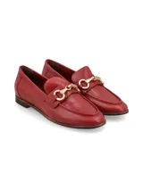 Mocasín de cuero color rojo con detalle de hebilla dorada.
