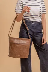 Cartera tipo bandolera de tamaño mediano confeccionada en símil cuero color marrón. Presenta una correa larga regulable, dos compartimientos principales y un bolsillo frontal con cierre de cremallera.