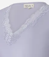 Conjunto de pijama lila compuesto por una blusa de manga corta con escote en V y detalle de encaje, y un pantalón capri con cintura elástica y detalle de encaje en el ruedo.