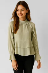 Blusa color verde claro de poliéster con cuello alto fruncido, mangas largas con puños elásticos y volados en el frente.