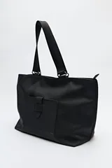 Bolso blanco de símil cuero con terminación suave. Tiene asas anchas de cinta negra y un bolsillo frontal con solapa.