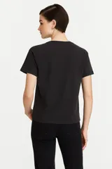 Remera blanca de algodón con estampado de flores azules y naranjas, de corte clásico y cuello redondo.
