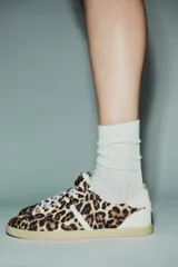Zapatillas deportivas con estampado animal, cordones blancos y suela color caramelo.