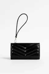 Billetera negra con textura matelasse en forma de V y tachas plateadas. Incluye correa de muñeca extraíble.