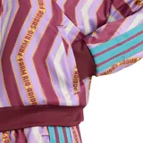 Campera Adidas Farm Tiro Tt para mujer, con estampado geométrico en tonos borgoña, lila y blanco. Presenta cierre frontal, cuello alto y mangas largas con las tres líneas características de Adidas en color celeste. Logo de Adidas bordado en el pecho.