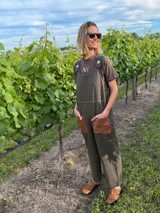 Mono enterito verde militar de corte suelto, con bordados a tono hechos a mano y bolsillos de cuero marrón.