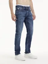 Pantalón de jean azul oscuro, de corte slim y talle alto, con diseño de cinco bolsillos y cierre con cremallera y botón.