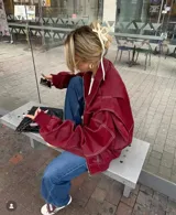 Campera oversize de cuero ecológico color bordó, con costuras blancas a contraste y cierre frontal.