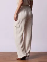 Pantalón cargo de lino color blanco, marca Marissa Olivia. Tiene pretina ancha elastizada con lazo de ajuste, bolsillos inclinados delanteros y bolsillos laterales con botón.