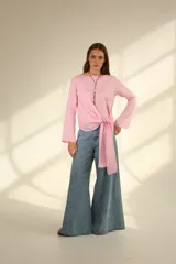 Blusa blanca de lino con escote en V cruzado, mangas largas y lazo en la cintura.