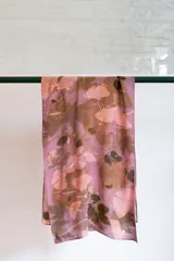 Pañuelo rectangular de seda natural color rosa cochinilla con impresión botánica de hojas de Ginkgo Biloba.