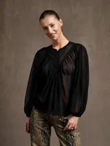 Blusa negra traslúcida con cuello mao, mangas largas abullonadas y cierre frontal con botones.