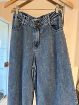Pantalón de jean celeste de corte ancho con cintura alta y bolsillos delanteros y traseros.