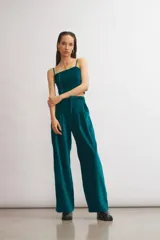 Pantalón de terciopelo azul marino, de corte sastrero amplio con pinzas, bolsillos laterales y largo al tobillo.
