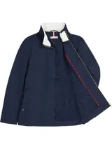 Campera Tommy Hilfiger azul marino con cuello alto blanco, cierre frontal con cremallera, mangas largas y cinturón ancho de tela del mismo tejido para ajustar en la cintura.