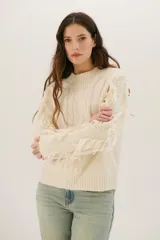 Sweater color arena de tejido de punto con cuello redondo y mangas largas con flecos.