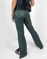 Pantalón de cuero verde oscuro, corte jean, tiro medio-alto y abertura lateral en el ruedo.