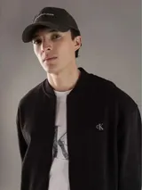 Gorra gris de algodón con visera curva y logo de Calvin Klein Jeans bordado en el frente. Ajuste trasero con hebilla metálica.