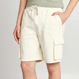Short de chándal color blanco hueso con bolsillos laterales tipo cargo.
